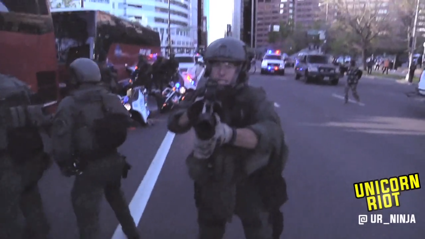 A member of DPD Metro/SWAT cocks a teargas grenade launcher at Unicorn Riot producer on April 29, 2015