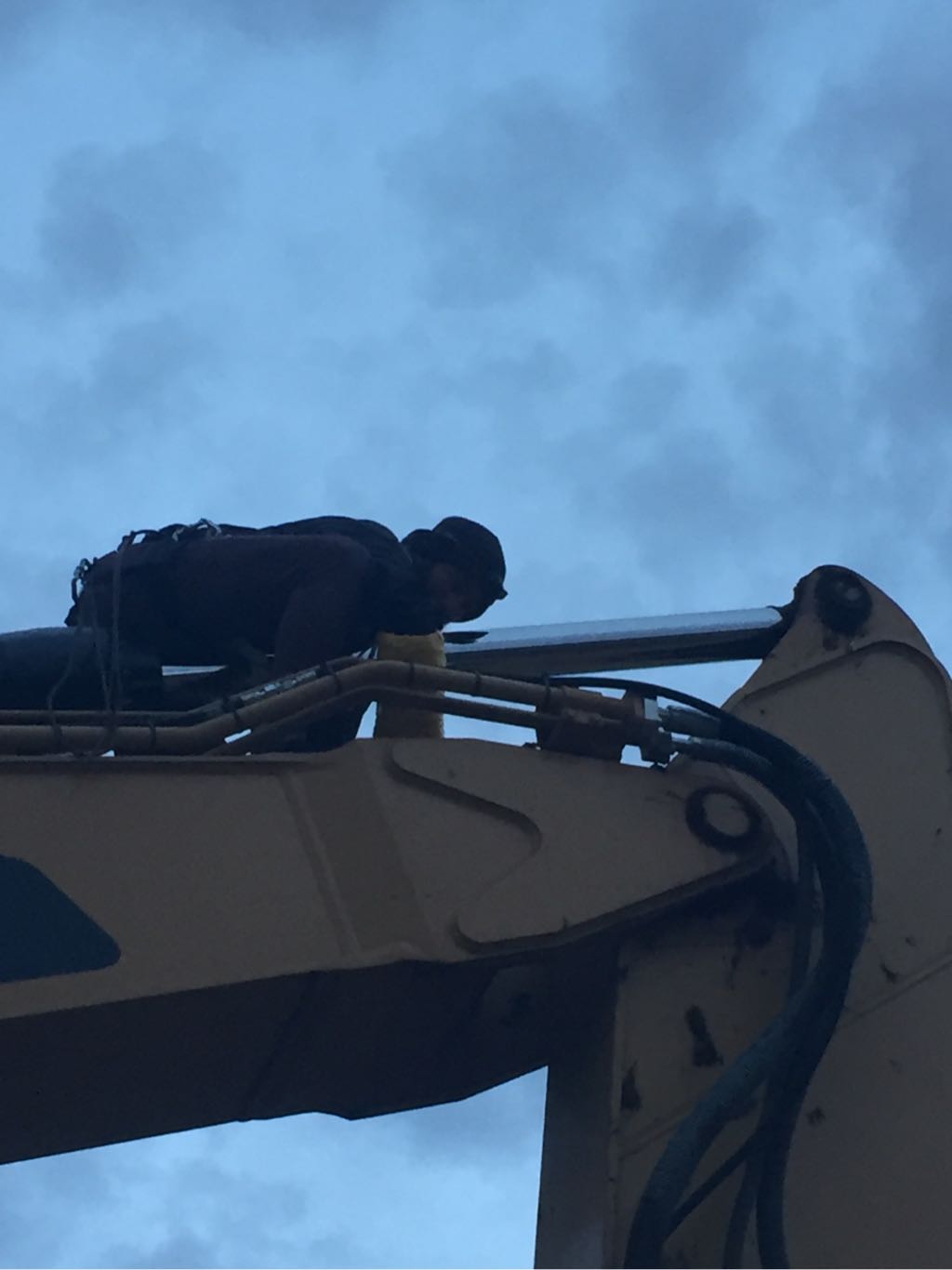 A water protector attaching themselves to the hydraulic arm of a DAPL excavator using a lockbox device