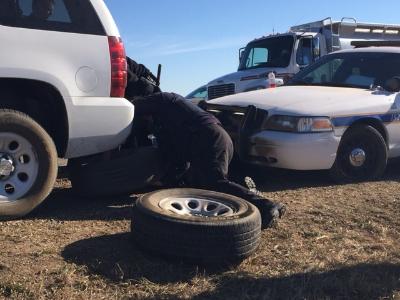 Law enforcement changing a flat tire on Highway 6. Image credit: KFYRTV